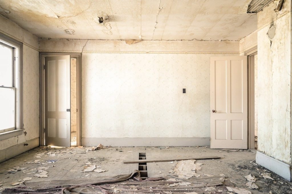 Interior of a dilapidated room showing water damage and disrepair